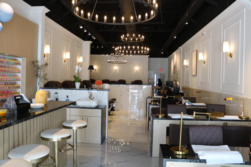 The NailVibe Cool Springs salon — gold chandeliers, marble bar and manicure stations